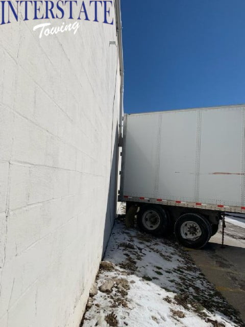Semi Towing Team Dislodges Truck From In Between 2 Buildings